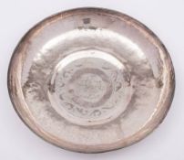A Persian silver bowl: of beaten circular form, centered with script enclosed by a scroll border,
