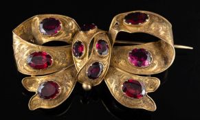 A late Victorian garnet ribbon bow brooch,: set with oval cut garnets,