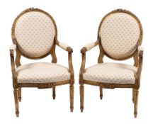 A pair of carved and giltwood fauteuils in Louis XVI taste, early 20th century,
