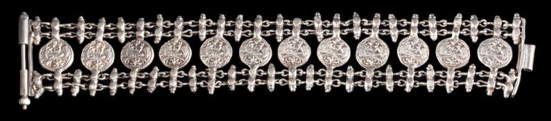 A silver coloured bracelet,: the circular panels with duos of peacocks,