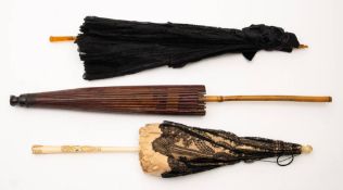 Three parasols; comprising a Betaille black lace and silk parasol,: a late 19th Century black lace,