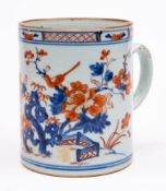 A Chinese Imari tankard: painted with a long-tailed bird perched on a peony branch in a fenced