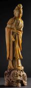 A large Chinese carved soapstone figure of Guanyin: her hair in a high chignon,