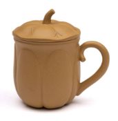 A Chinese Yixing cup and saucer: of buff colour and of melon shaped form with rustic handle and