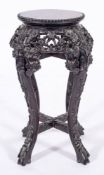 A Chinese carved and stained hardwood stand, late 19th century,: the circular top with beaded edge,