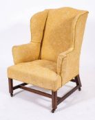 A George III mahogany and upholstered wing back armchair, circa 1770,: with 'camel back',