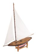 An early 20th century pond yacht: fully rigged over simulated plank deck,