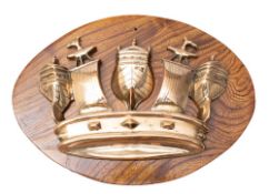 A Royal Navy brass crown tompion: later mounted on an elm oval plinth, 28 x 38cm.