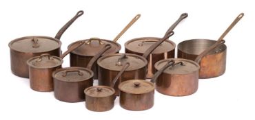A collection of nine copper saucepans and covers: of graduated size with iron and brass handles.