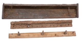 A rustic wooden shelf: with twin nail hooks, 111cm wide, two other rustic wooden bars with hooks,