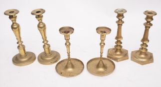 A pair of 19th Century brass candlesticks: with turned stems and circular bases, 27cm high,