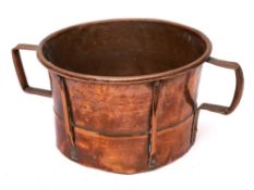 A copper circular twin-handled miller's grain bucket: with raised work decoration, 29cm diameter.