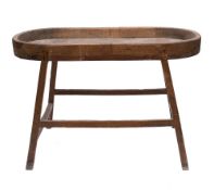 A 19th Century oval pine shallow trough: on integral stand with splayed legs, united by stretchers,
