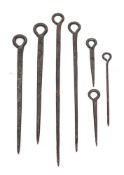 A collection of seven early iron meat skewers: of varying sizes.