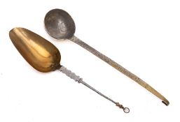 A white metal and brass hanging ladle: with hooked end, decorated handle and circular bowl,