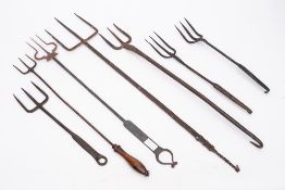 A collection of seven three pronged toasting forks: of various designs.