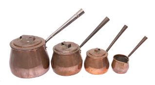 Three copper saucepans and covers: of graduated size with iron handles and a brandy saucepan of