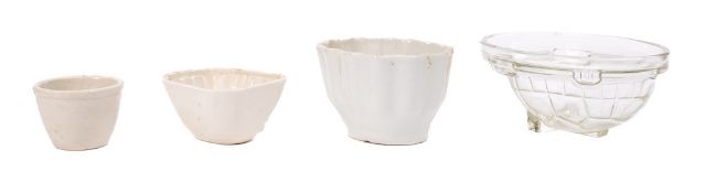 Four pottery jelly or aspic moulds:, two glass examples, one in the shape of a rabbit,