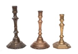 An 18th Century brass candlestick: with turned stem and circular mound base with petal edge, 23.