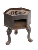 A cast iron hexagonal brazier: with inset grille, on tripod splayed legs, 25cm across, 33cm high.