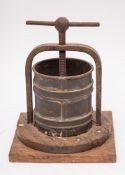 A 19th Century iron tongue press: with tin drum, central screw thread and wood platform, 30cm high.