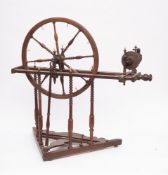 A 19th Century fruitwood spinning wheel: with turned baluster spindle spokes,