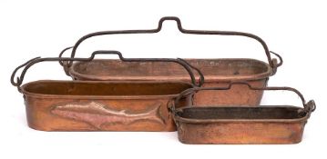 Three graduated oval copper fish kettles: with iron loop handles, 40cm - 68cm long.