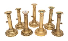 Seven various 19th Century brass ejector candlesticks: on circular bases.
