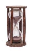 A 19th Century glass sand timer: in a circular wood stand with turned uprights.
