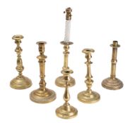 A collection of five various 19th Century brass candlesticks: and a brass candlestick oil lamp.