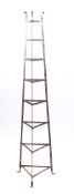 An iron triangular nine tier graduated pan stand: in green finish, 180.