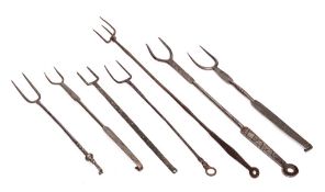 An iron three pronged flesh fork: and six various twin pronged toasting forks.