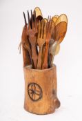 A collection of horn table and other spoons:, various wooden forks, contained in a wood piggin.