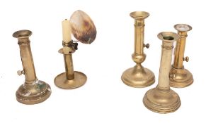 Five various brass ejector candlesticks: with circular bases.