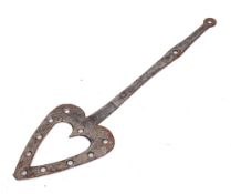 A steel cooking slice: of pierced heart shape with shaped handle and ring terminal, 55cm long,