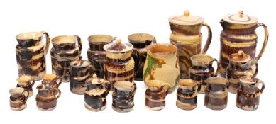 A group of cream and brown splashed pottery kitchen jugs;, some with covers,
