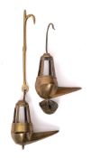 Two 18th Century brass Crusie lamps: with suspension rods, pointed oil wells and lantern surmounts,