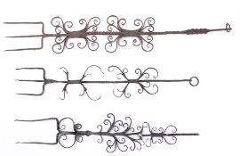 Two decorative three pronged forks: with scroll decorated handles and a similar two pronged fork.