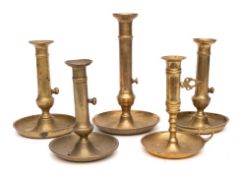 Five 19th Century brass ejector candlesticks: with saucer bases.