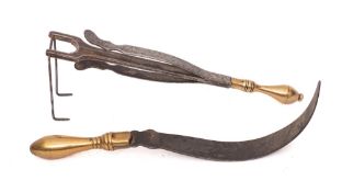 A steel and brass handled potato rake:,