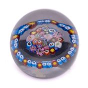 A Scottish glass paperweight: the centre with a close pack millefiori surrounded by a garland,