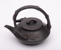 A small Yixing stoneware teapot and cover: of dark brown hue and of squat form with branching faux