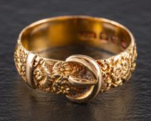 A Victorian 18ct gold buckle ring,: with engraved floral decoration, Birmingham, 1887, ring size P,