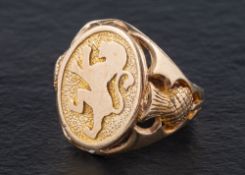 A 9ct gold signet ring depicting the lion rampant of Scotland,: openwork thistles to shoulders,
