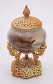 A Royal Worcester porcelain pot pourri jar and pierced cover: the jar supported on three scrolling
