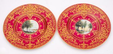 A pair of Royal Worcester porcelain plates: the centres painted with a circular panel decorated