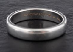 A platinum ring by Tiffany,: signed 'Tiffany & Co', dated 1999 with hallmarks for London, 2005,