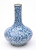 A Chinese blue and white 'peony' bottle vase: painted overall with flowering peony and dense