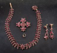 A 19th century, gold, foiled back, garnet parure of stylised flowerhead design,