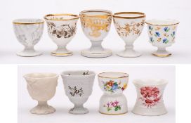 A group of seven egg cups and two egg hoops: including one in parian; one egg hoop by Minton,